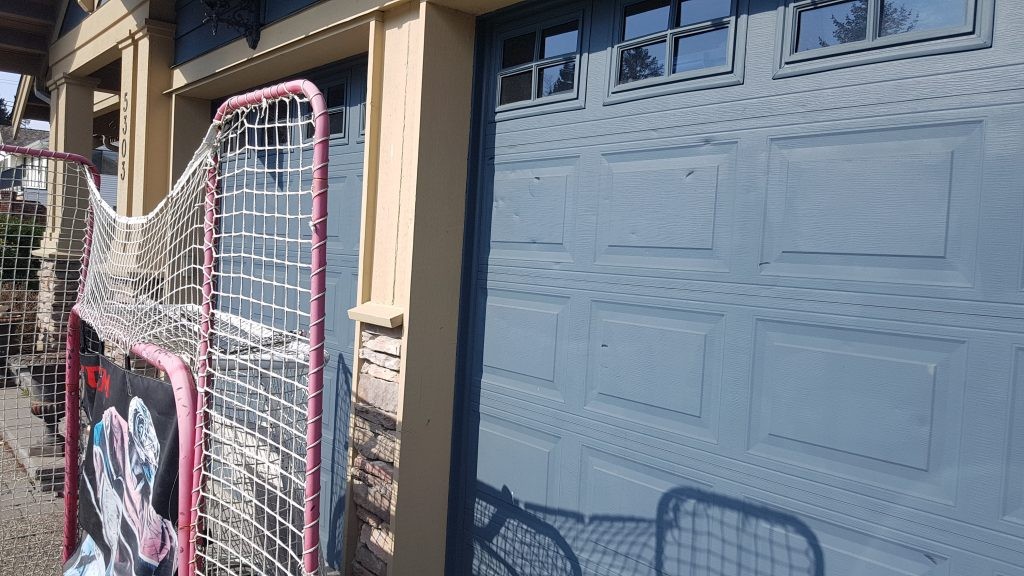 Garage door with hockey puck damage.