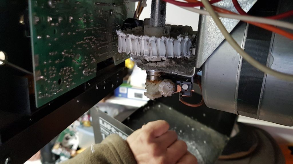 view of overused broken gear in a garage door motor.