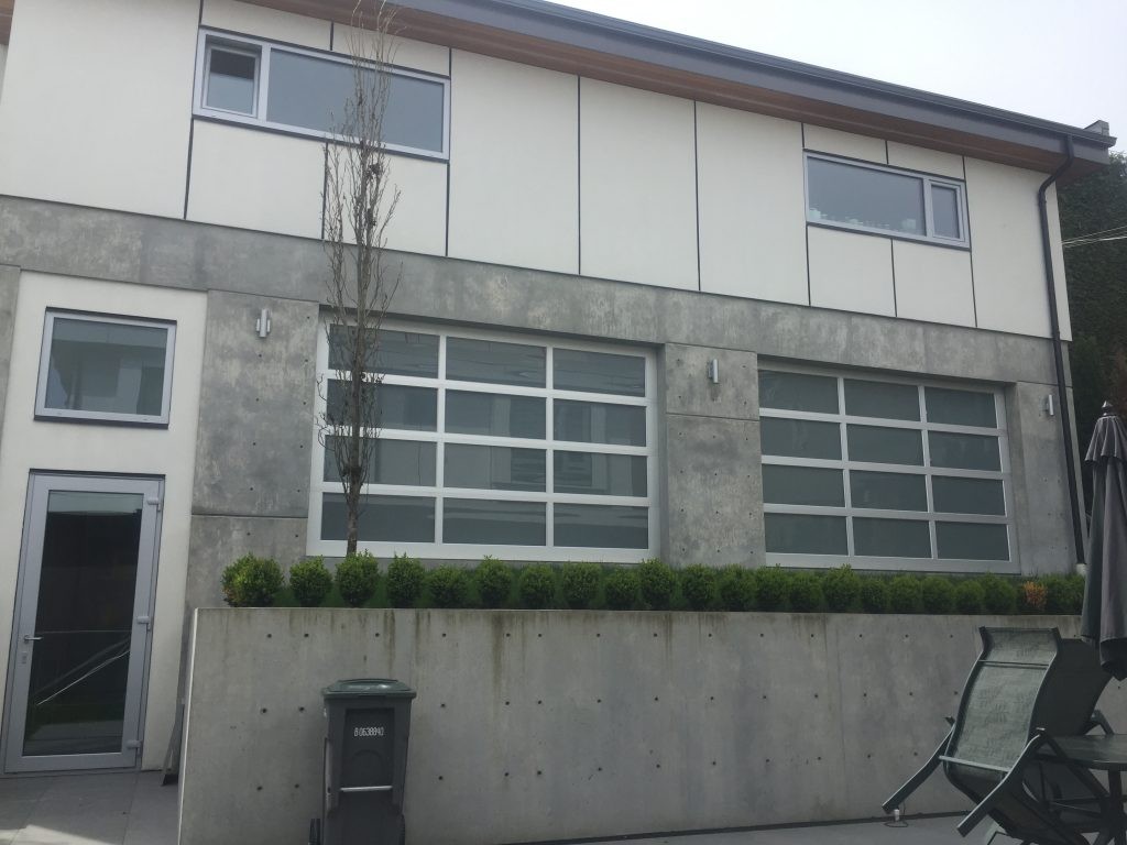 Two garage doors that are installed in a concrete building.