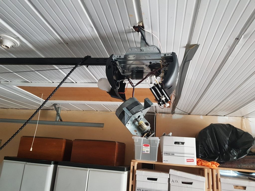 View of a garage door motor that is in the midst of being repaired.