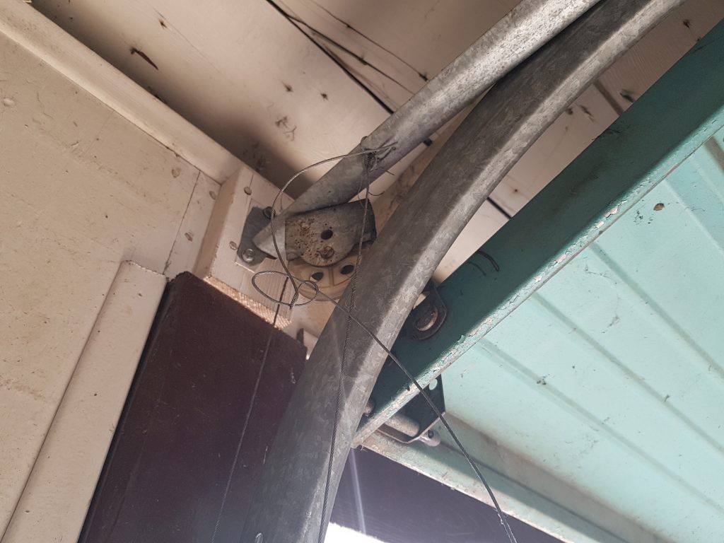 View of garage door that has cables that are not properly setup.