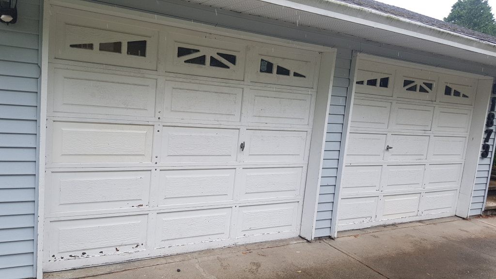 View of garage door that has been repaired. Both garage doors have panel's replaced
