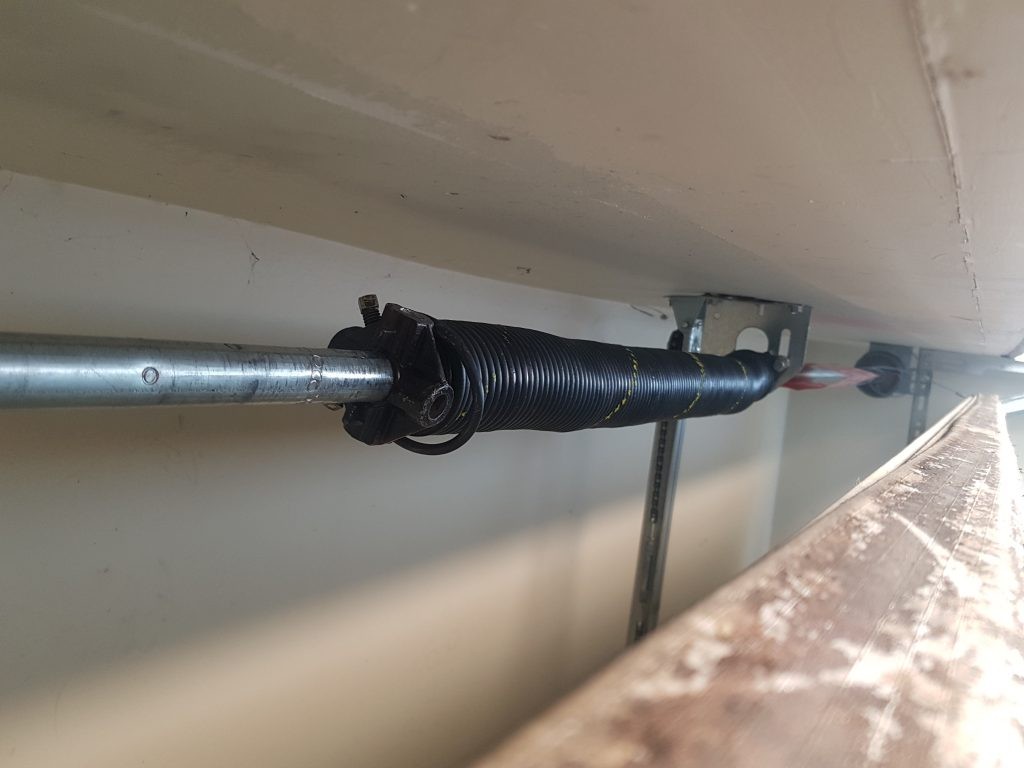 View of garage door spring that has a failed winding cone and can't keep it's tension