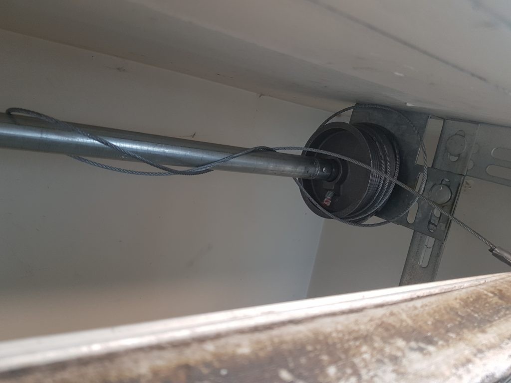 view of unspooled cable on garage door drum