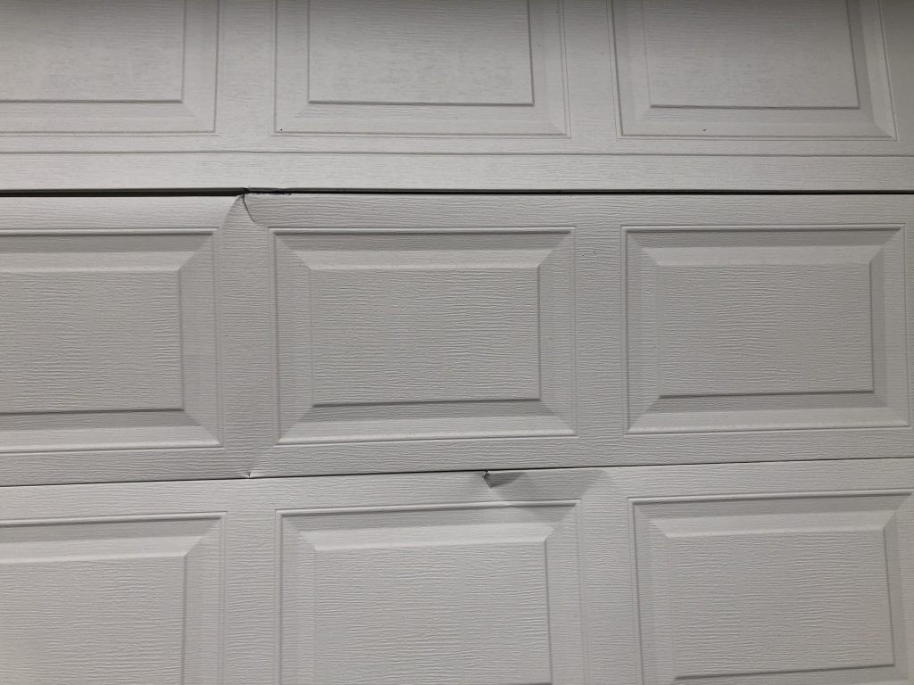 View of dented garage door in Cloverdale.